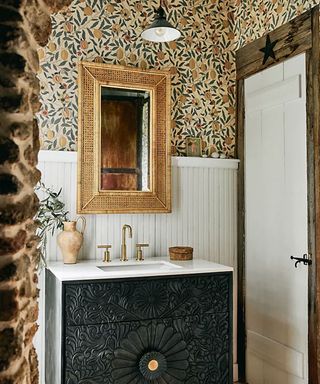 Cozy, boho bathroom with sink, mirror and wallpaper