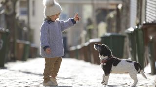 Child teaching dog the heel command