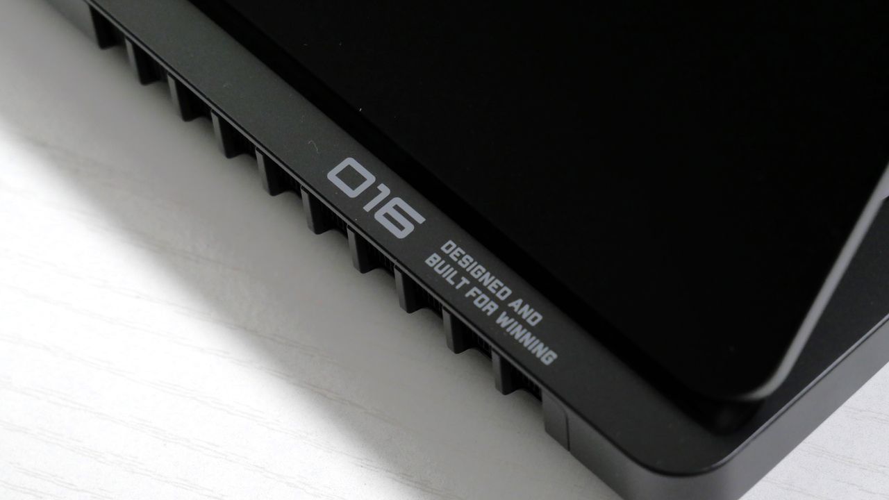 HP Omen Max 16 on a white desk, highlighting the 016 logo on the bottom right of the hinge.