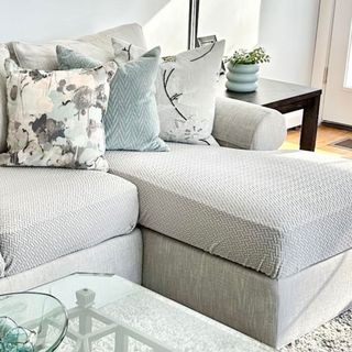 Grey l-shaped sofa with grey sofa cover and botanical throw pillows