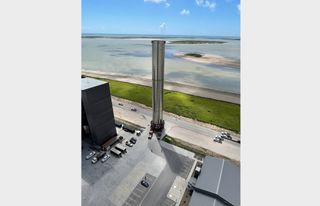 SpaceX rolls a full-size Super Heavy booster from the high bay to the launch pad at its Starbase site in South Texas on July 1, 2021. The booster will undergo ground tests to help prepare for an orbital test flight of SpaceX's Starship transportation system. That flight will use a different Super Heavy booster, company founder and CEO Elon Musk said.