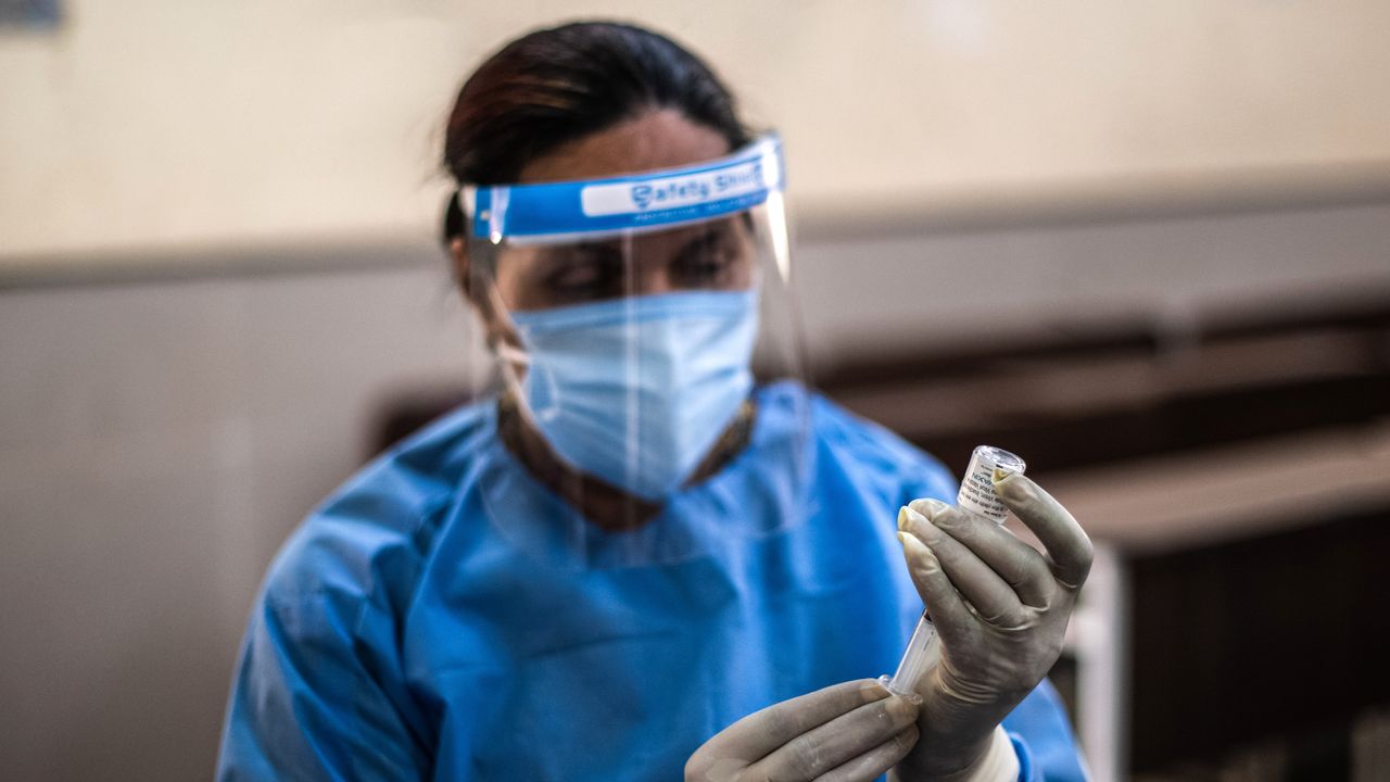 A medical worker draws up a Covid vaccine in New Dehli, India