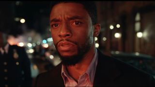 Chadwick Boseman staring ahead in disbelief at a crime scene in 21 Bridges.