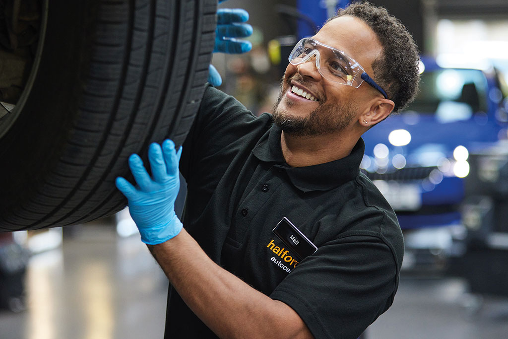 Halfords employee checking a car tyre
