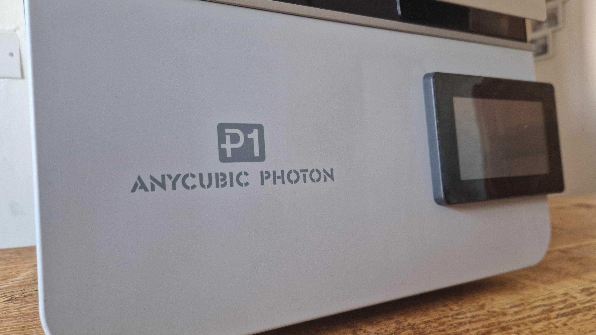 Anycubic Photon P1 logo and screen, on a wooden surface