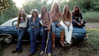 Black Oak Arkansas leaning against a car