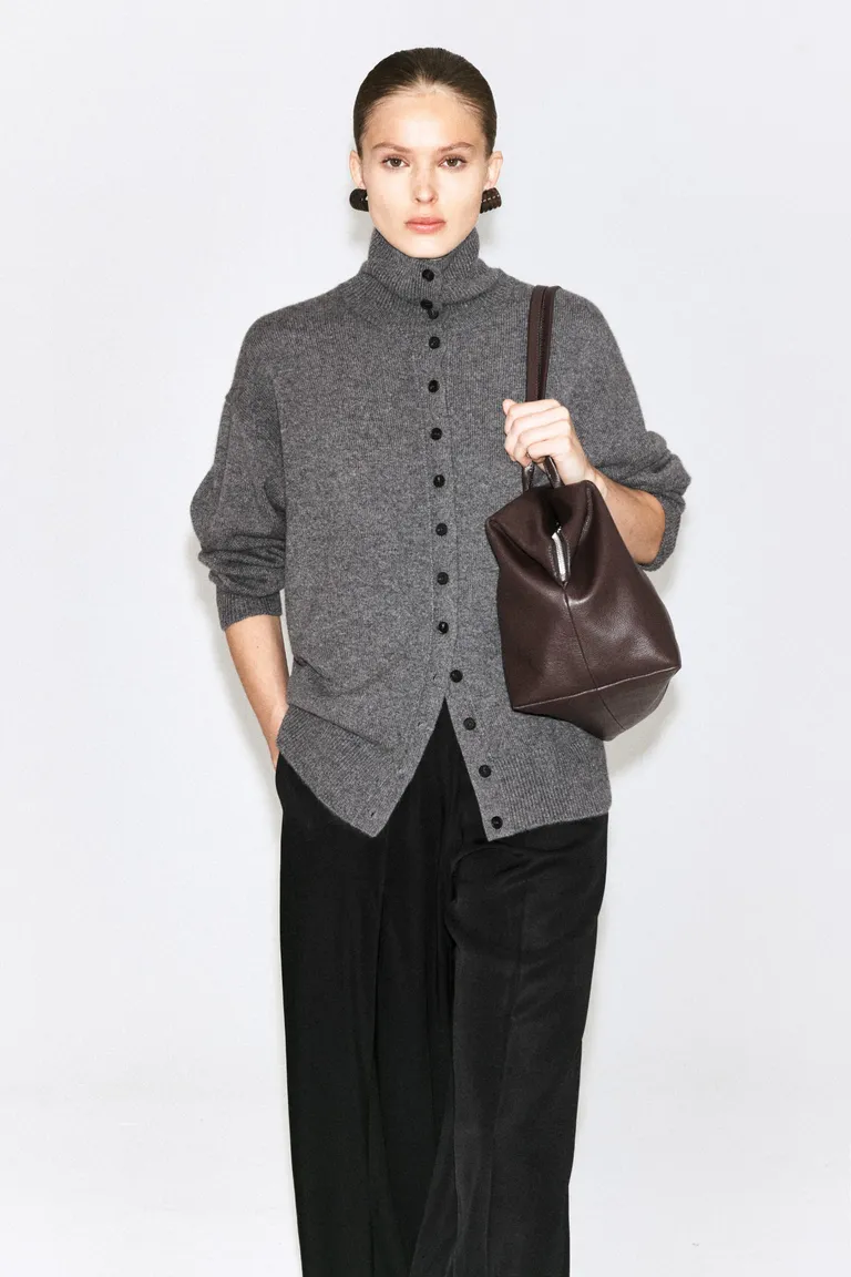 Model wears grey funnel neck cardigan
