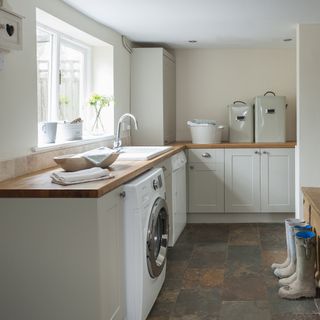 Cream utility room with washing machine and boots