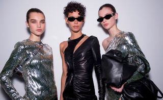 Backstage at the Off-White A/W 2018 Paris show models in reflective silver dresses with long sleeves