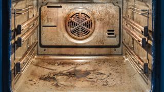 A dirty oven with burnt residue on the base