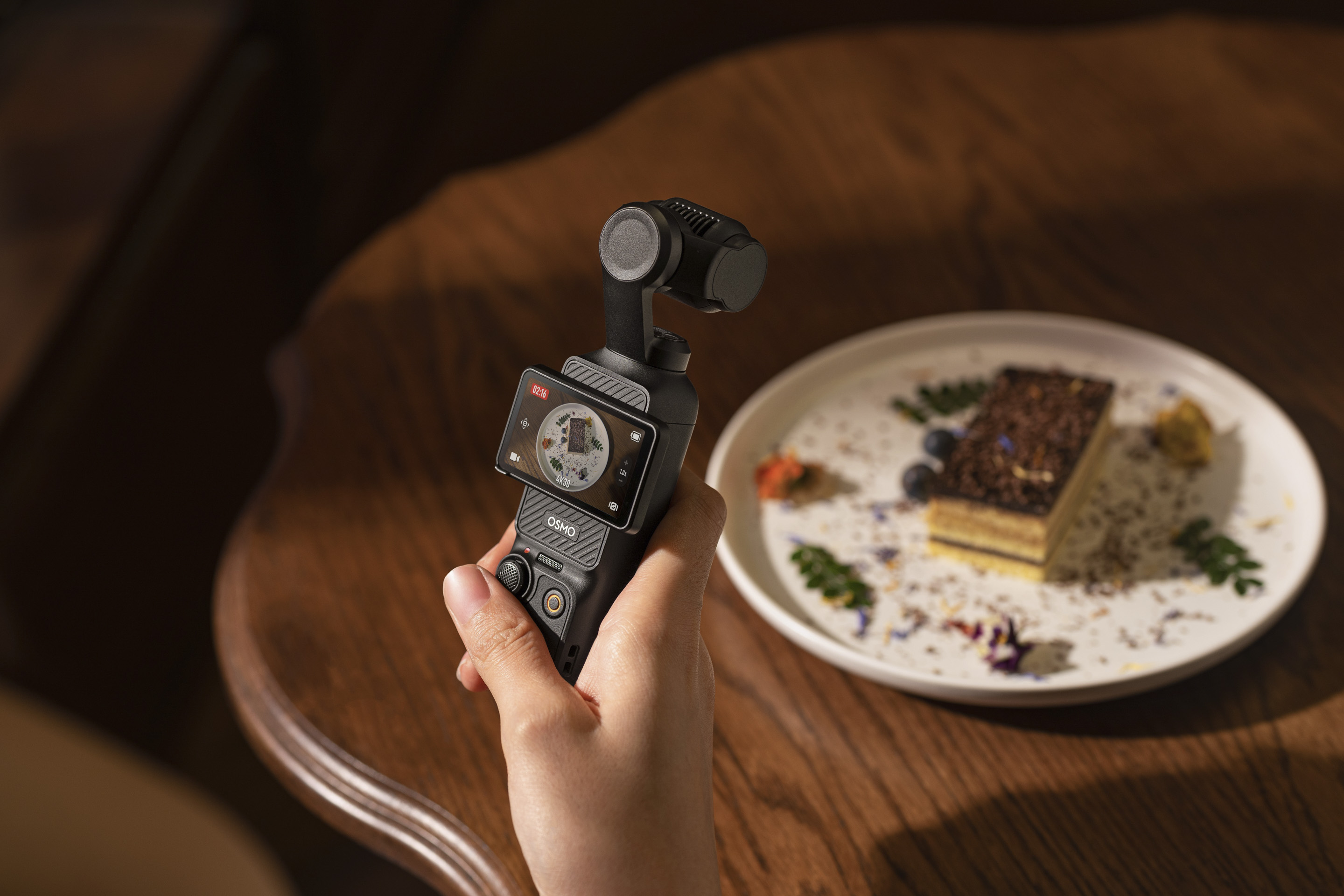 DJI Pocket 3 in the hand shooting food video content with screen in landscape format
