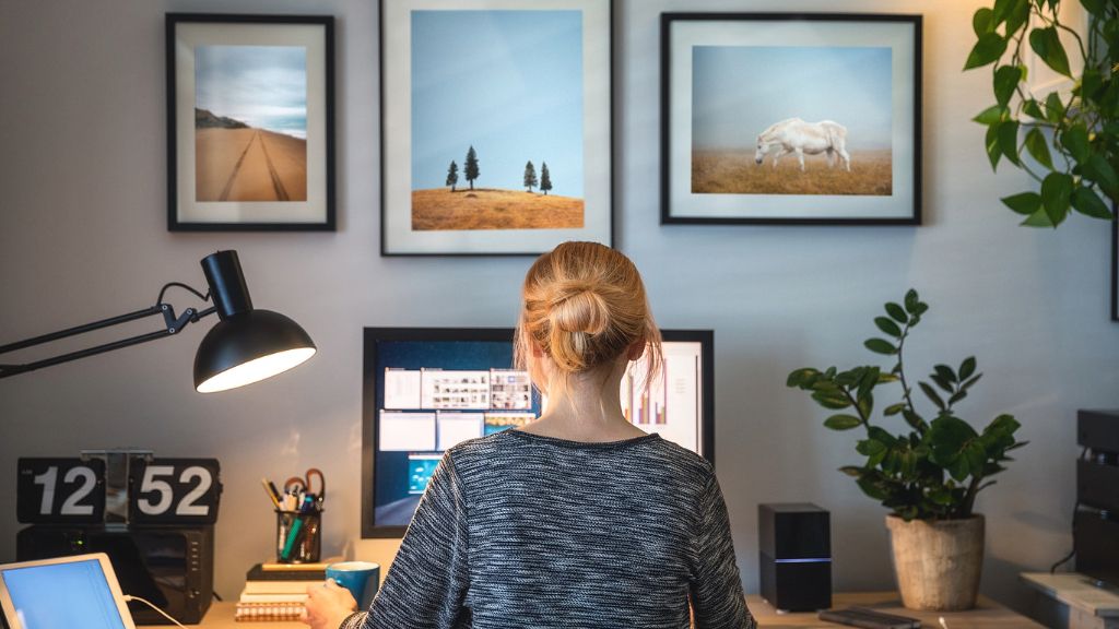 A woman working at a desk with a plant