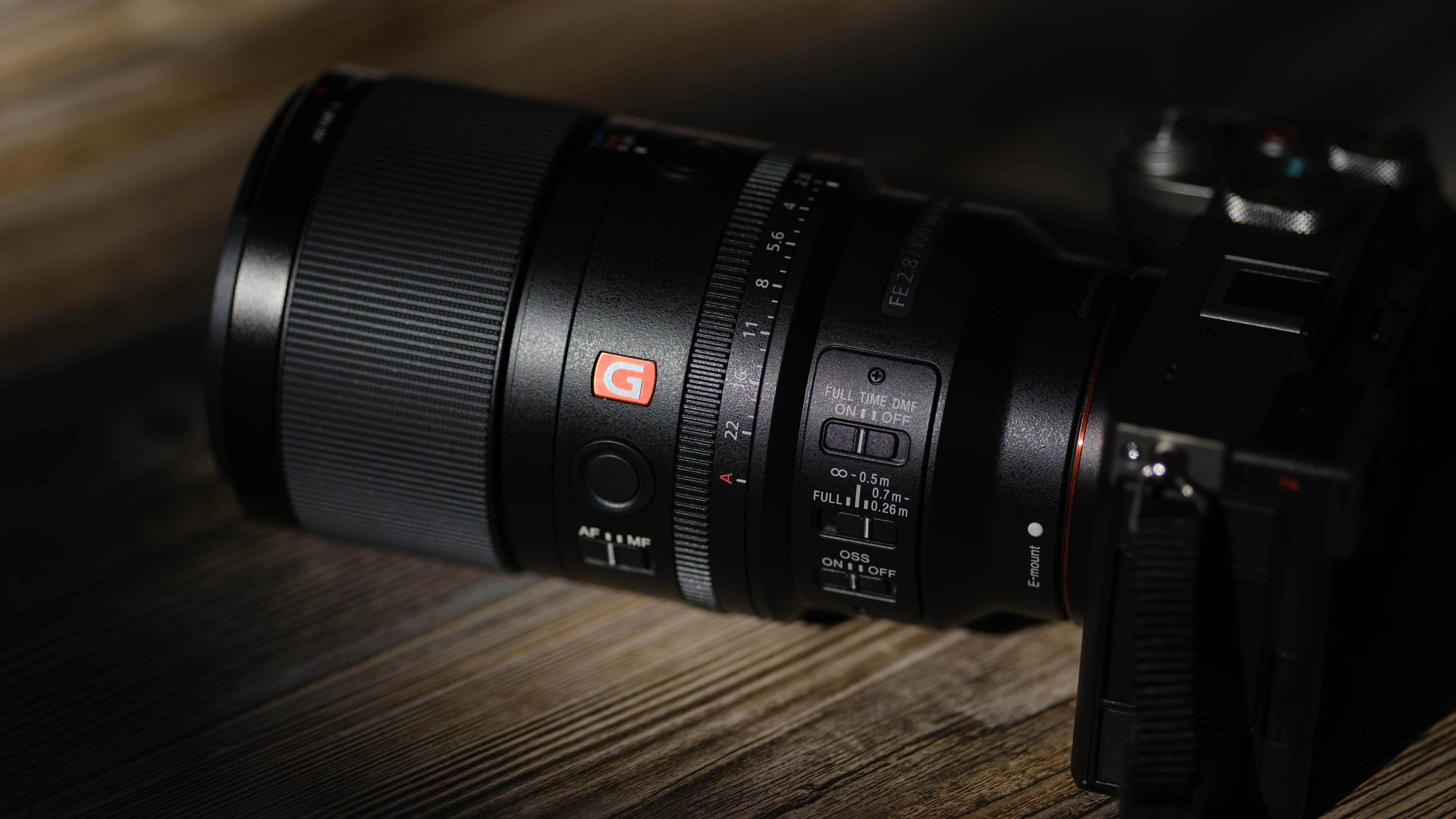 The Sony FE 100mm f/2.8 Macro GM OSS on a wood background
