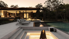 outdoor area with a sunken firepit, a pool, and sun loungers