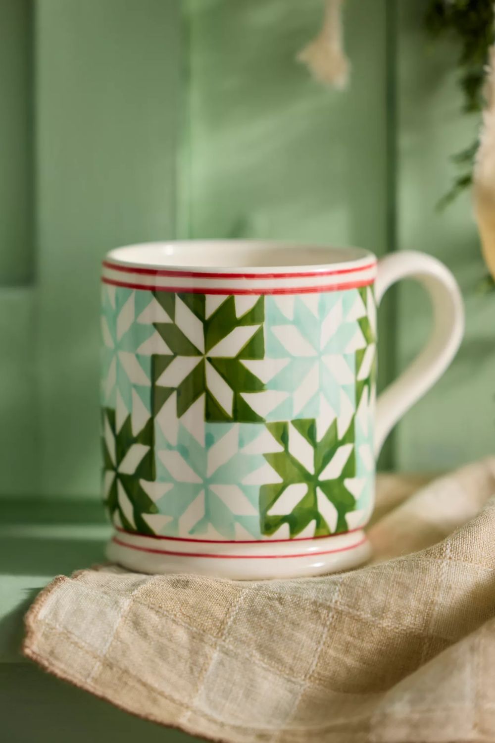 Mug with blue and green Christmas quilted design and red trim