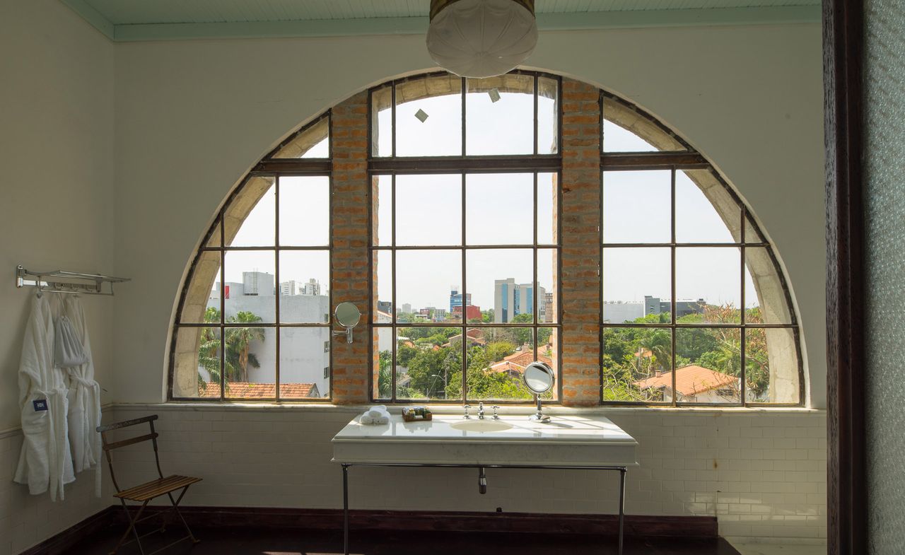 A view of a bathroom and arched window inside La Alondra Factoría — Asunción