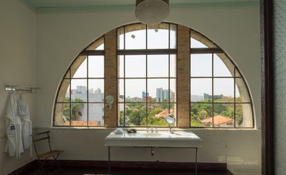 A view of a bathroom and arched window inside La Alondra Factoría — Asunción