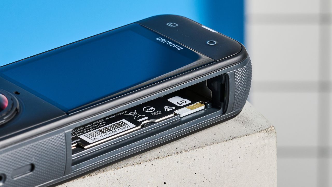 The Insta360 X5 with its battery compartment open and no battery in place, showing the Micro SD card slot