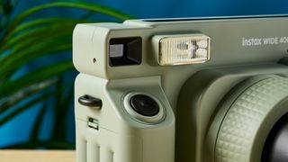 A sage green Fujifilm Instax Wide 400 instant camera