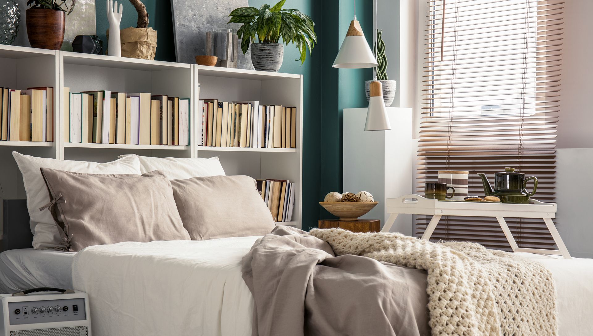 bookshelf behind bed in small room