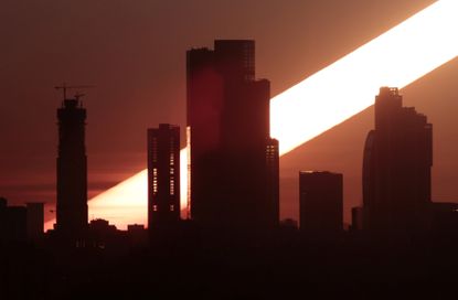 The sun rises behind the skyscrapers of the Moscow International Business Centre, also known as "Moskva-City", in Moscow,