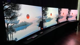 LG G3 OLED TV on stand with other TVs showing landscape image