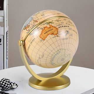 A yellowed retro looking globe on a yellow gold stand