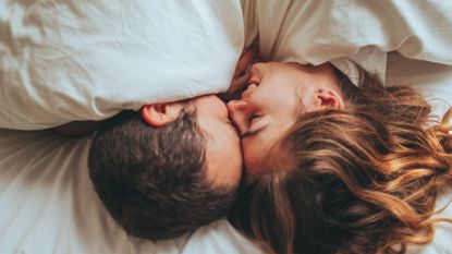 couple in bed under the sheets