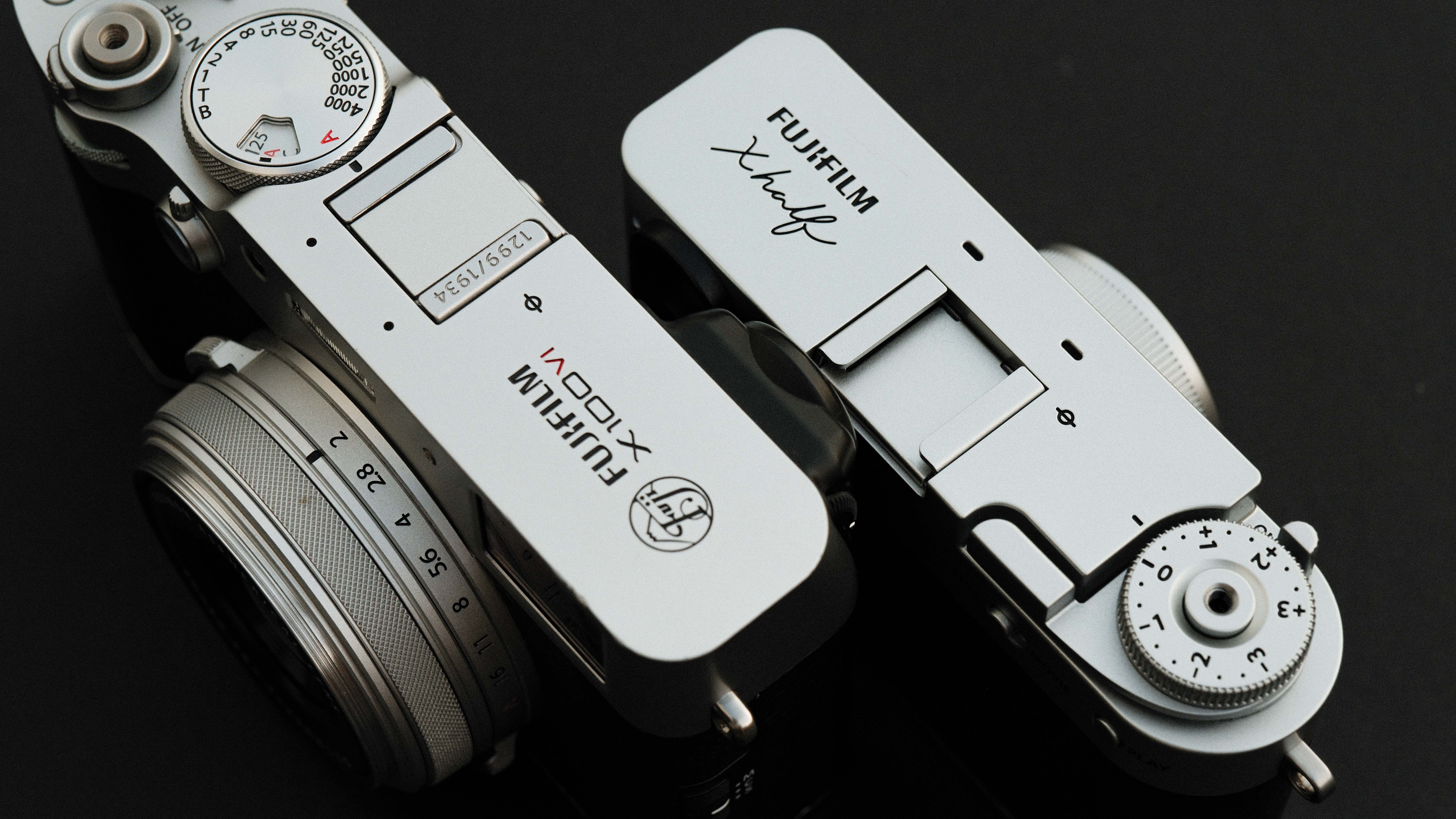 Fujifilm X Half camera next to a Fujifilm X100VI camera