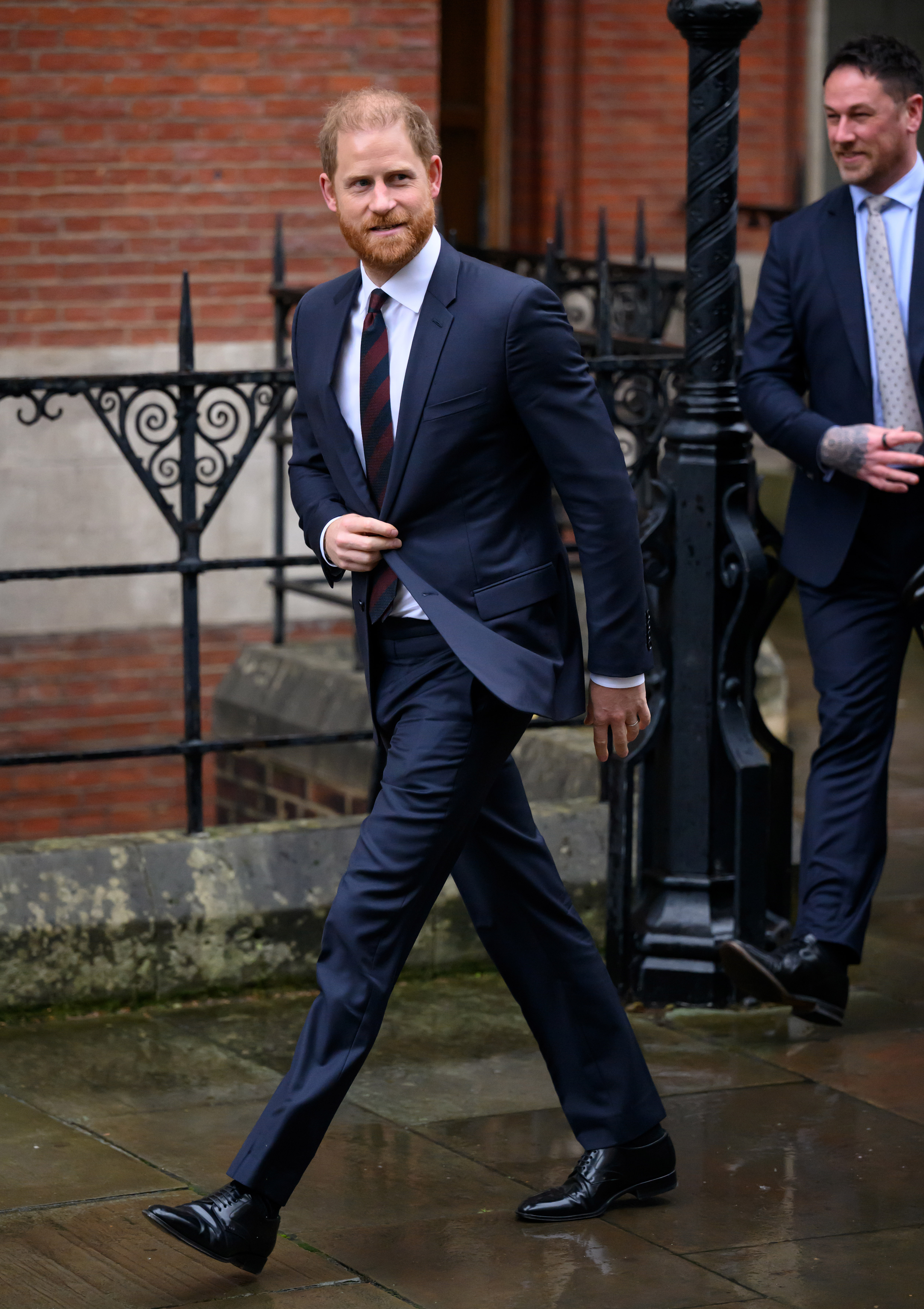 Prince Harry wearing a suit walking outside court
