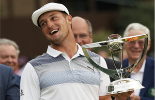Bryson DeChambeau smiles while holding The Northern Trust trophy in 2018
