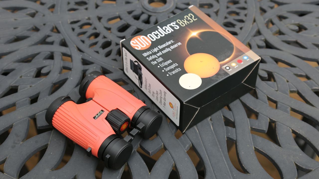 Lunt SunOculars 8x32 next to their box on a black metal table.