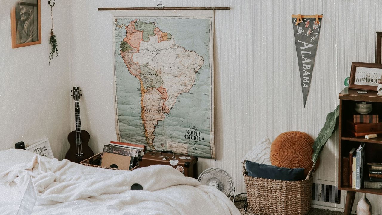 Bedroom with records, messy sheets, and banner