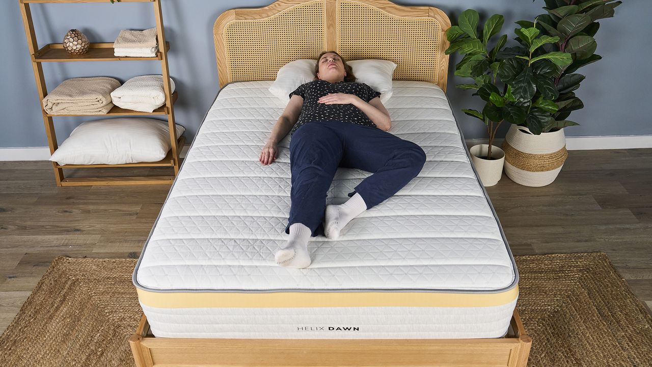 A woman lies on the Helix Dawn Mattress in a back sleeping position