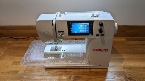 Bernina 475 QE review, represented by a photo of a sewing machine on a wooden table