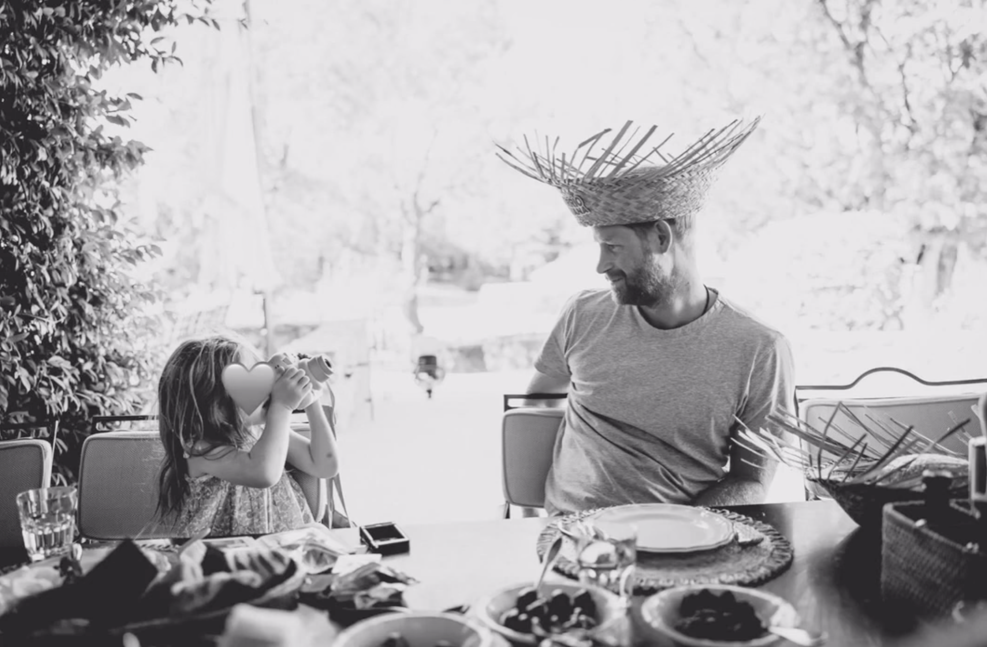 Princess Lilibet takes a photo of Prince Harry wearing a straw hat