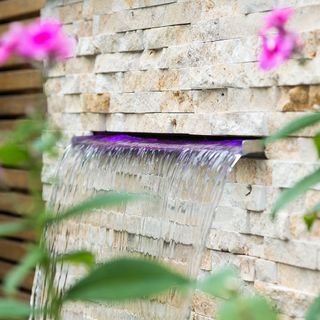 garden water through stone wall