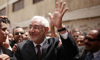 Egyptian presidential candidate Abdel Moneim Aboul Fotouh waves outside a polling station: The Islamist is using a unifying message to appeal to more secular voters.