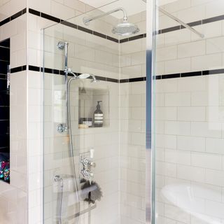 bathroom with glass partition shower and white tiles