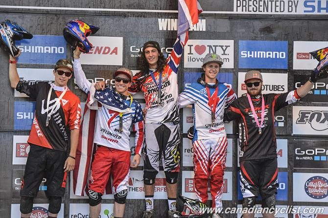 Josh Bryceland atop the elite men's downhill World Cup podium in Windham, NY
