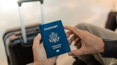 Traveler's hand holding USA passport at airport