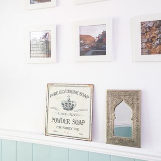 bathroom with white wall and frames photos