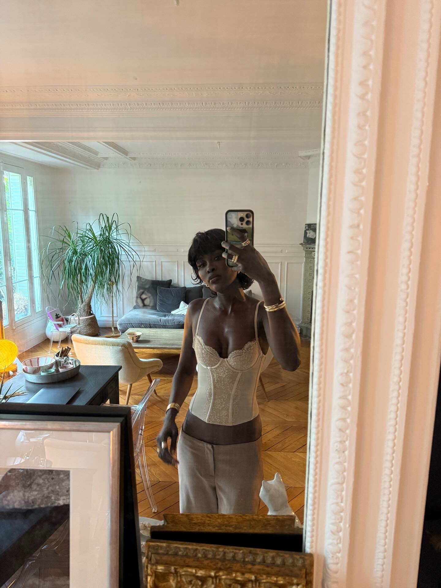 A woman taking a selfie in a Parisian apartment with a mullet bob hairstyle