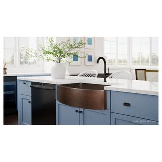 copper sink in kitchen with blue cupboards