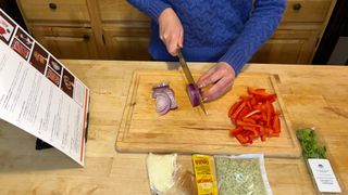 Preparing Green Chef meal kit by chopping onions