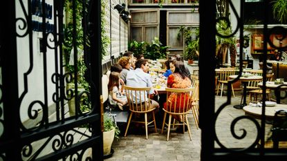 View through the gate of a multi-generational family dining at an outdoor restaurant