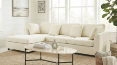 a living room with a white sofa, a small coffee table, and a jute rug
