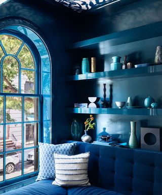 blue living room with arched window blue walls and blue couch