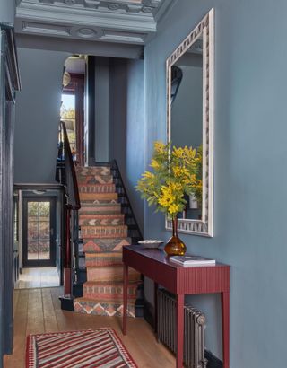 entryway with blue walls and a mirror