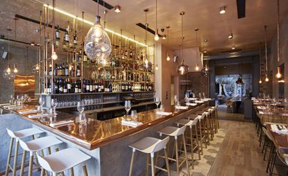 Bandol restaurant copper topped bar, oak flooring low-hanging pendant lighting 